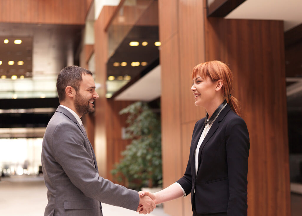 Business woman shaking hands with business man